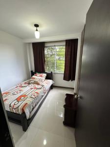 a bedroom with a bed and a window at Casa en Marinilla cerca a guatape y el peñol in Marinilla