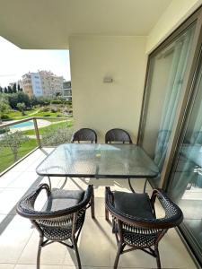 a glass table and chairs on a balcony at NEW STUNNING OCEAN APRT IN "OASIS MAR" Wi-Fi in Portimão