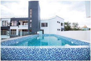 a swimming pool in front of a house at Cascadia Hotel Apartments by GF Greenland in Kigali