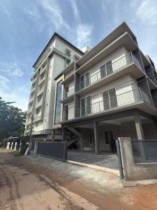 卡卡纳德The Nexus Hotel Kakkanad的街边的一栋白色大楼