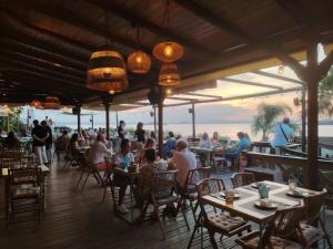 a group of people sitting at tables in a restaurant at Chalet entre dos mares. in San Blas