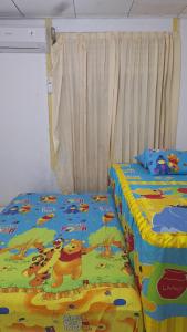 a bedroom with two beds with winnie the pooh sheets at 88HappyHomestay in Luwuk