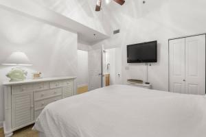 巴拿马城海滩Shores of Panama 108的一间带床和平板电视的白色卧室
