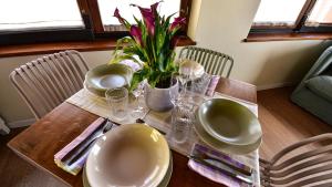 a table with plates and a vase with a plant on it at Il Giardino di Berbech Città Alta in Bergamo