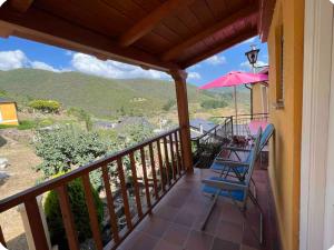 a balcony with chairs and a table and an umbrella at Medulillas de Yeres in Yeres +8 photos