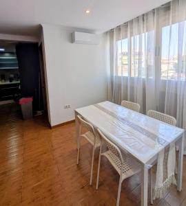 a white table and chairs in a room with a window at Vacaciones tierra y mar Apartamento en el centro in El Campello