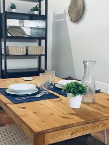 a wooden table with plates and glasses and a plant on it at Casa São Pedro by Portus Alacer in Sousel