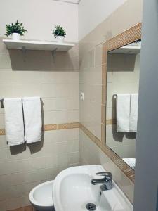 a bathroom with a sink and a toilet and a mirror at Casa São Pedro by Portus Alacer in Sousel