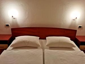 a bedroom with a bed with two white pillows at Koperinn in Koper