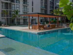 a swimming pool with a gazebo next to a building at Salinas del Mar Suite in Santa Marta