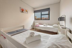 a bedroom with two beds with a heart shaped towel on them at 48 On Possession Island in Swakopmund