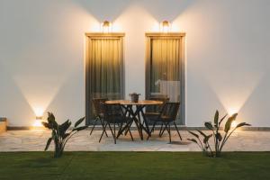 een patio met een tafel, stoelen en verlichting bij Capital Suites Skopelos in Neo Klima