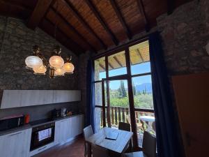 a kitchen with a table and a large window at Residence Val Di Monte in Malcesine