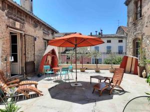 a patio with a table and an umbrella and chairs at Appartement 84m2 avec terrasse in Crest