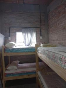 two bunk beds in a room with a window at Cabaña LA BALSA in Villa Urquiza