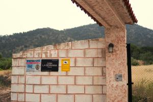 a brick wall with signs on the side of it at Casa la Serrana in Yecla