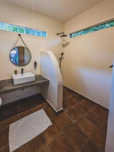 a bathroom with a sink and a mirror at Muti Entebbe in Entebbe +34 photos