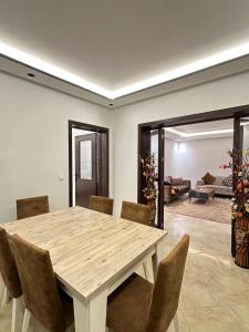 Un comedor con mesa y sillas de madera. en Résidence Redouan, en Tánger