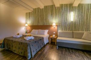 a hotel room with a bed and a couch at Relais Bellaria Hotel & Congressi in Bologna