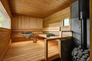 a sauna with wooden walls and wooden flooring at BredvikBastu&Inn in Espoo