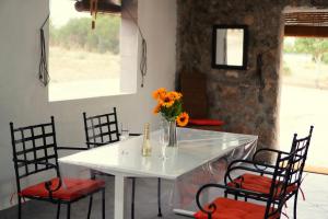 a white table with chairs and a vase of flowers on it at Casa la Serrana in Yecla