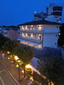 a large white building with lights in front of it at Hotel Berna in Eraclea Mare