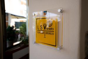a yellow sign on the side of a building at Hotel Berna in Eraclea Mare