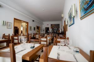 a restaurant with wooden tables and chairs and wine glasses at Hotel Berna in Eraclea Mare