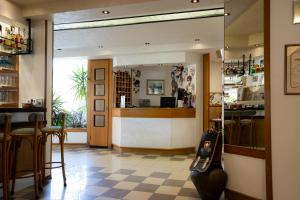 a bar with a counter and chairs in a restaurant at Hotel Berna in Eraclea Mare