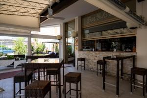 a restaurant with tables and chairs and a bar at Hotel Berna in Eraclea Mare
