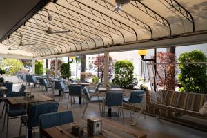a restaurant with tables and chairs and windows at Hotel Berna in Eraclea Mare