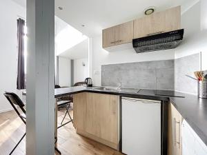 une cuisine avec un évier et un plan de travail dans l'établissement La Capsule Colocation Appartement partagé à deux personnes maximum, à Rouen 2 autres photos