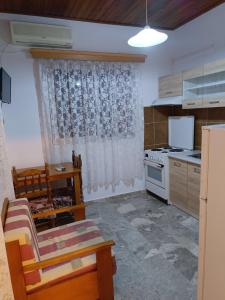 a kitchen with a couch and a table and a stove at Barreira Beachfront Rooms 3 in Kalamata