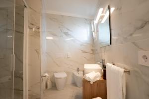 a white bathroom with a toilet and a shower at Hotel Berna in Eraclea Mare
