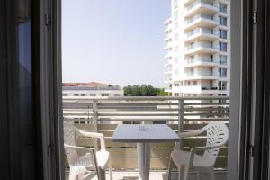 a balcony with a table and chairs and a building at Hotel Berna in Eraclea Mare