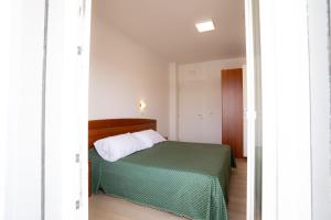 a bedroom with a bed with a green bedspread at Hotel Berna in Eraclea Mare