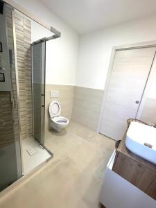 a bathroom with a toilet and a shower and a sink at I Centenari Longevity Rooms in Lotzorai