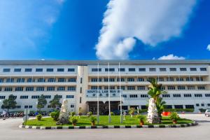 un grande edificio bianco con palme di fronte di Sofu Inn a Jelutong