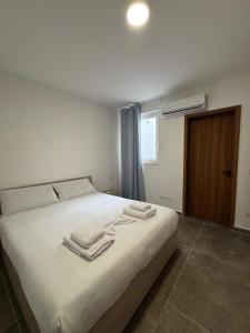 a bedroom with a white bed with towels on it at Spacious Stay new 2 Bed and Balcony in Taʼ Penza