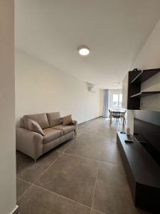 a living room with a couch and a table at Spacious Stay 2 Bed with Terrace - by HostMT in Fgura +17 photos