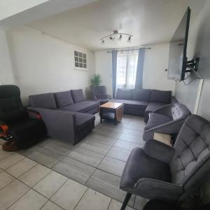 a living room with a couch and chairs and a tv at Grande maison BREST in Brest