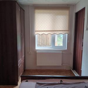 a bedroom with a window with a blind on it at Ципель 1 in Szack