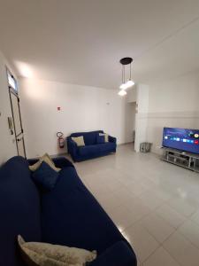 a living room with a blue couch and a flat screen tv at La casa del delfino in Policoro