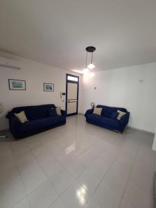 a living room with two blue couches in a room at La casa del delfino in Policoro