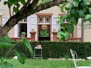 a chair in the grass in front of a house at Manoir de La Gravette Authentic French Manor Experience in Montauban