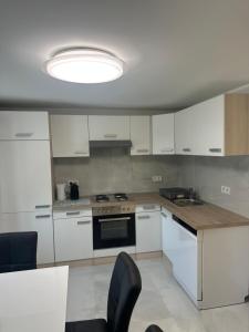 a kitchen with white cabinets and a large light at Ferienwohnung NAMALI in Schiefling am See