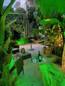 a patio with a table and an umbrella and plants at Urban Garden Suite-Samos Center in Samos