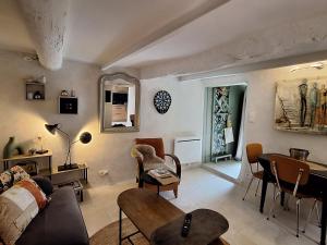 una sala de estar con un sofá y una mesa en La 54 Provence, en LʼIsle-sur-la-Sorgue