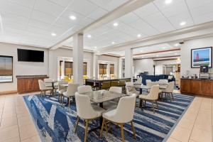 a lobby with tables and chairs and a flat screen tv at Comfort Inn & Suites Kenosha-Pleasant Prairie in Kenosha
