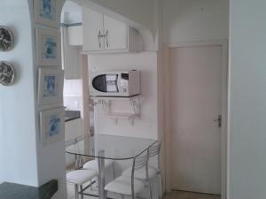 巴拉奈里奥-坎布里乌Apartamento no centro, bem localizado, na praia的厨房配有玻璃桌和微波炉 更多17张照片
